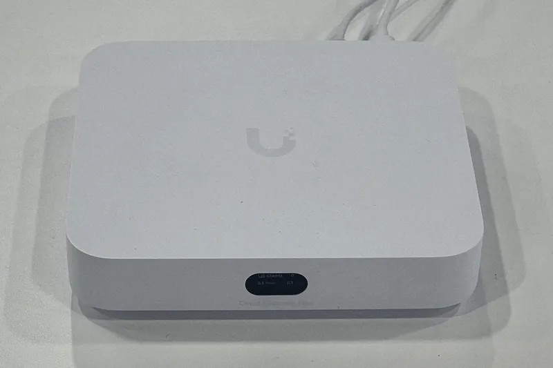 A UniFi Cloud Gateway Max, a compact white router and network controller